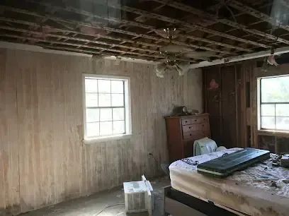 Bedroom with the ceiling and wall paneling removed after storm water